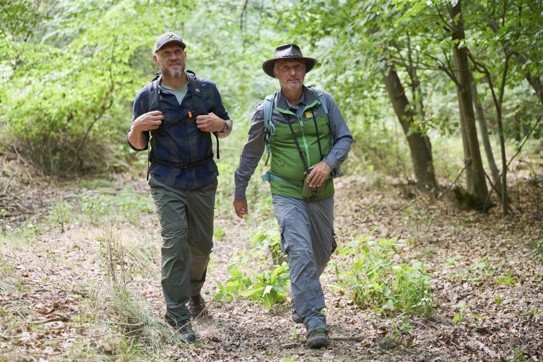 Hermann Maier geht mit Ranger durch den Wald